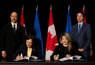 Ukraine's Ambassador to Canada Yuliya Kovaliv signs an agreement with Canada's Foreign Affairs Minister Melanie Joly while Ukraine’s Prime Minister Denys Shmyha and Canada’s Prime Minister Justin Trudeau look on in Toronto, Ontario, Canada April 11, 2023. REUTERS/Carlos Osorio