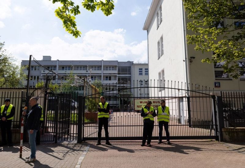 Security guards stand in front of the gate of the school belonging to the Russian embassy in Warsaw, Poland, April 29, 2023. REUTERS