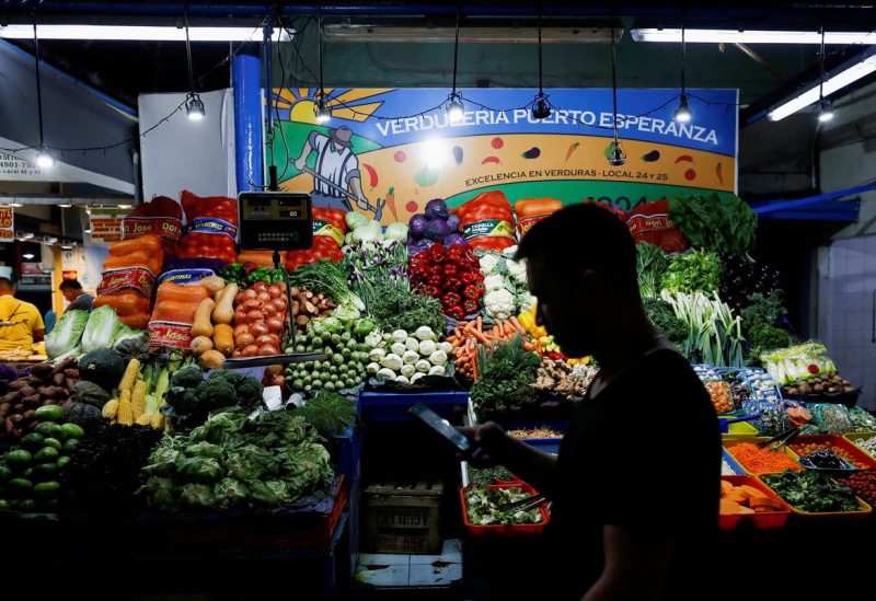 A costumer walks past a greengrocery store, as Argentina's annual inflation rate tore past 100% in February - REUTERS