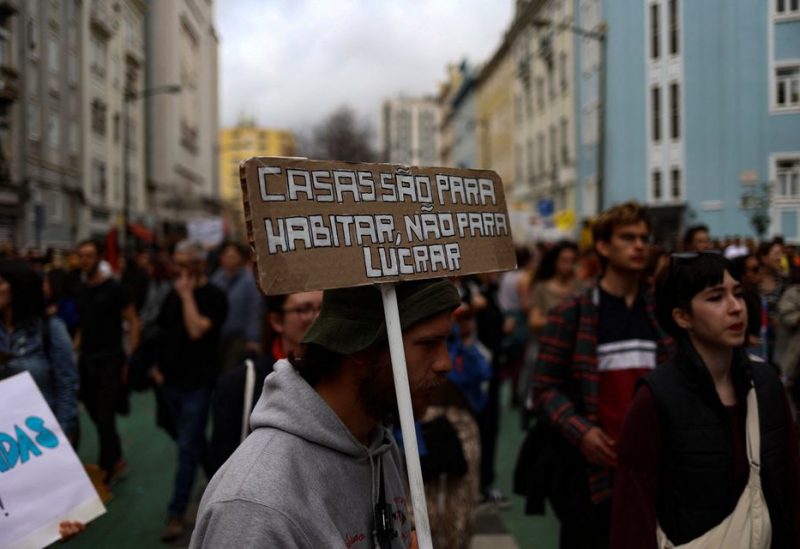 A man carries a placard that reads: "Houses are for living, not for profits" as people demonstrate for the right to affordable housing in Lisbon, Portugal, April 1, 2023. REUTERS