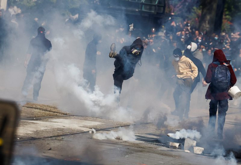 Demonstrators throw tear gas as they clash with police during the traditional May Day labour march, a day of mobilisation against the French pension reform law and for social justice, in Nantes, France May 1, 2023. REUTERS/Stephane Mahe