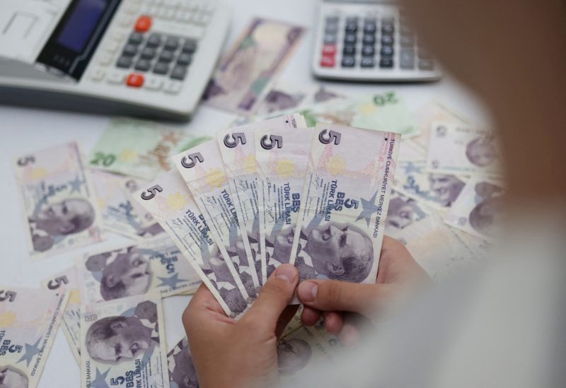 Woman holds Turkish Lira banknotes in this illustration taken May 30, 2022. REUTERS/Dado Ruvic/Illustration