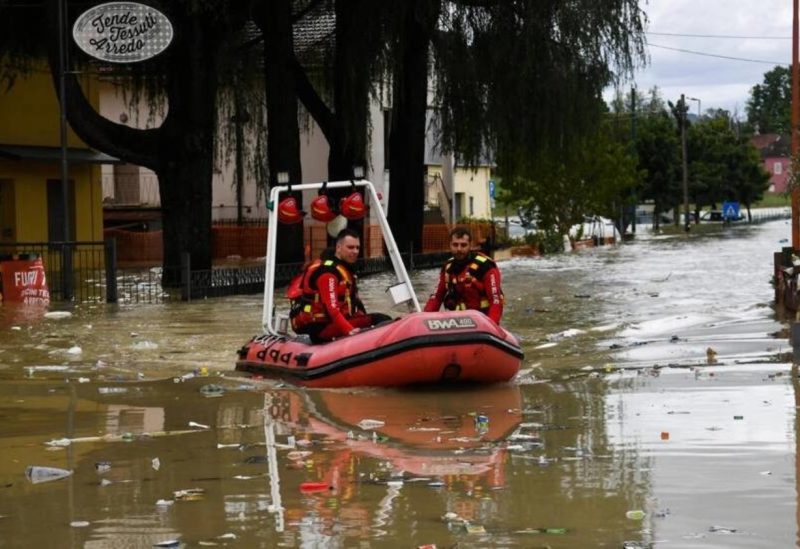 Volunteer firefighters ride their dinghy across a street flooded by the river Savio in the Ponte Vecchio district of Cesena, central eastern Italy, on May 17, 2023. Alessandro SERRANO / AFP