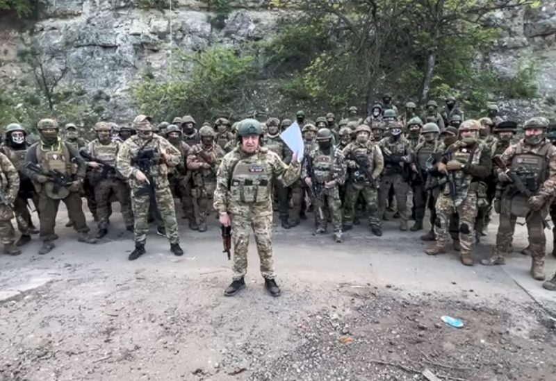 In this handout image taken from a video released by Prigozhin Press Service on Friday, May 5, 2023, head of Wagner Group Yevgeny Prigozhin reads his statement standing in front of his troops in an unknown location. (Prigozhin Press Service via AP)