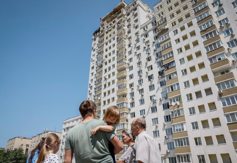 Local residents look at an apartment building, heavily damaged during a massive Russian drone strike, amid Russia's attack on Ukraine, in Kyiv, Ukraine May 30, 2023. REUTERS/Alina Smutko