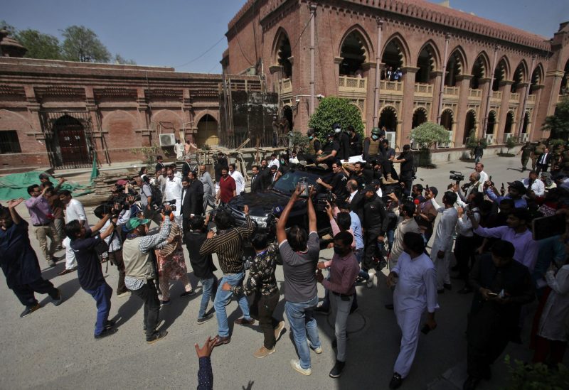 Members of the media film the vehicle carrying Pakistan's former Prime Minister Imran Khan and his wife Bushra Bibi as they arrive to appear at the High Court in Lahore, Pakistan, May 15, 2023
