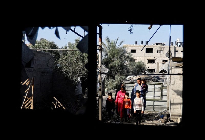 People look at a building, which was destroyed in an Israeli strike during Israel-Gaza fighting, after a ceasefire was agreed between Palestinian factions and Israel, in Deir Al-Balah, central Gaza Strip May 14, 2023. REUTERS/Ibraheem Abu Mustafa TPX IMAGES OF THE DAY