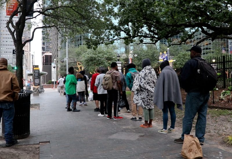 People line up for donated meals near the Houston Central Library, where the city is enforcing a law restricting the feeding of groups in public, Houston, Texas, U.S., April 24, 2023. REUTERS
