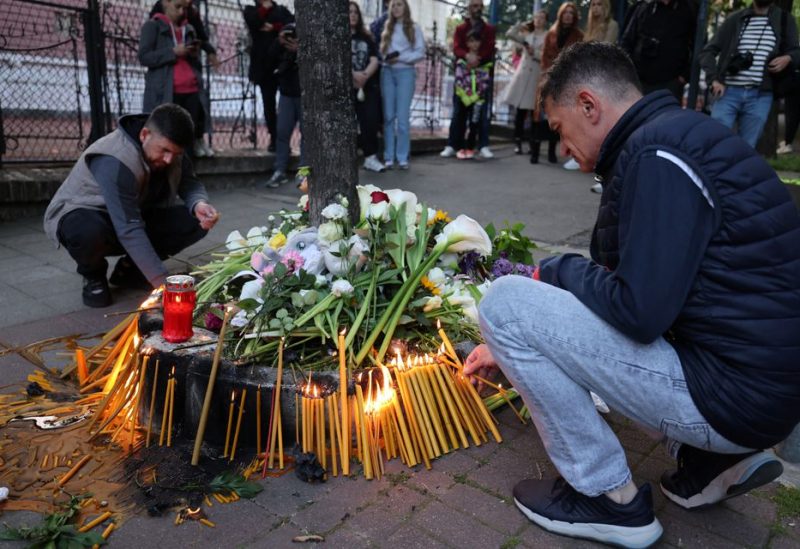 People light candles near a school after a boy, 13, opened fire on other students and staff at the school in Belgrade, Serbia, May 3, 2023. REUTERS