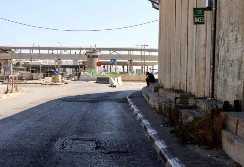 A man sits by the Qalandia checkpoint after, according to Israel's police, a suspected Palestinian gunman opened fire at the Israeli checkpoint in the occupied West Bank, wounding a security guard before he was shot dead by Israeli forces at the scene, June 24, 2023. REUTERS/Sinan Abu Mayzer