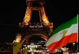 An Iran's flag is seen as the Eiffel Tower lit up with the slogan "Women, Life, Liberty" in support of Iranians, in Paris, France, January 16, 2023. REUTERS