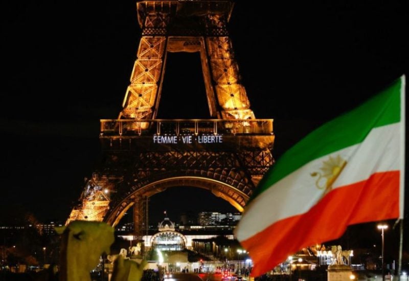 An Iran's flag is seen as the Eiffel Tower lit up with the slogan "Women, Life, Liberty" in support of Iranians, in Paris, France, January 16, 2023. REUTERS