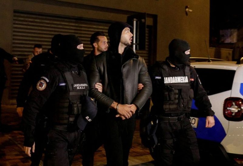 Andrew Tate and Tristan Tate are escorted by police officers outside the headquarters of the Directorate for Investigating Organized Crime and Terrorism in Bucharest (DIICOT) after being detained for 24 hours, in Bucharest, Romania, December 29, 2022. Inquam Photos/Octav Ganea via REUTERS