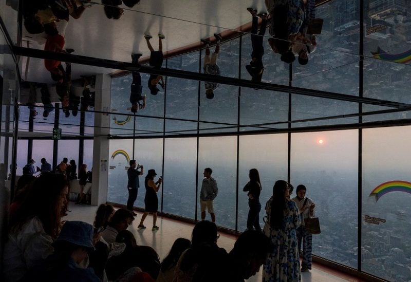 People take photographs as a smokey Toronto is seen from the CN Tower as wildfires in Ontario and Quebec continue to burn, in Toronto, Ontario, Canada June 6, 2023. REUTERS/Carlos Osorio
