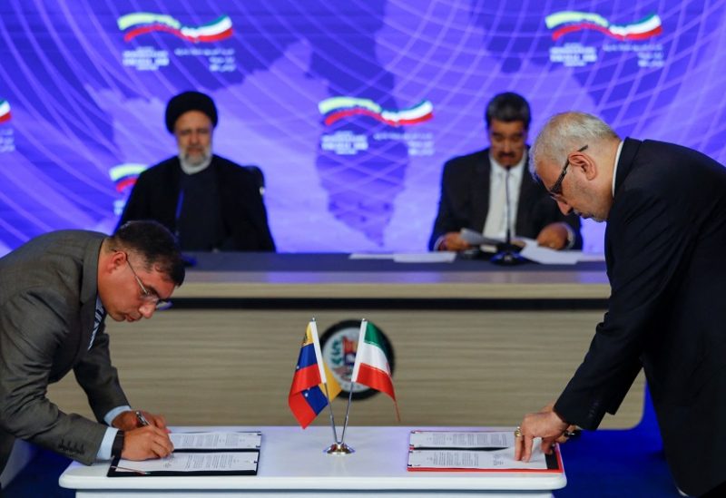 Venezuela's Minister of Petroleum Pedro Tellechea and his Iranian counterpart Javad Owji sign agreements during a meeting of Venezuela's President Nicolas Maduro and Iranian President Ebrahim Raisi at the Miraflores Palace, in Caracas, Venezuela June 12, 2023. REUTERS/Leonardo Fernandez Viloria