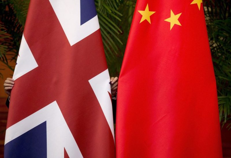 A worker adjusts British and China (R) national flags on display for a signing ceremony at the seventh UK-China Economic and Financial Dialogue "Roundtable on Public-Private Partnerships" at Diaoyutai State Guesthouse in Beijing, China September 21, 2015. REUTERS/Andy Wong/File Photo
