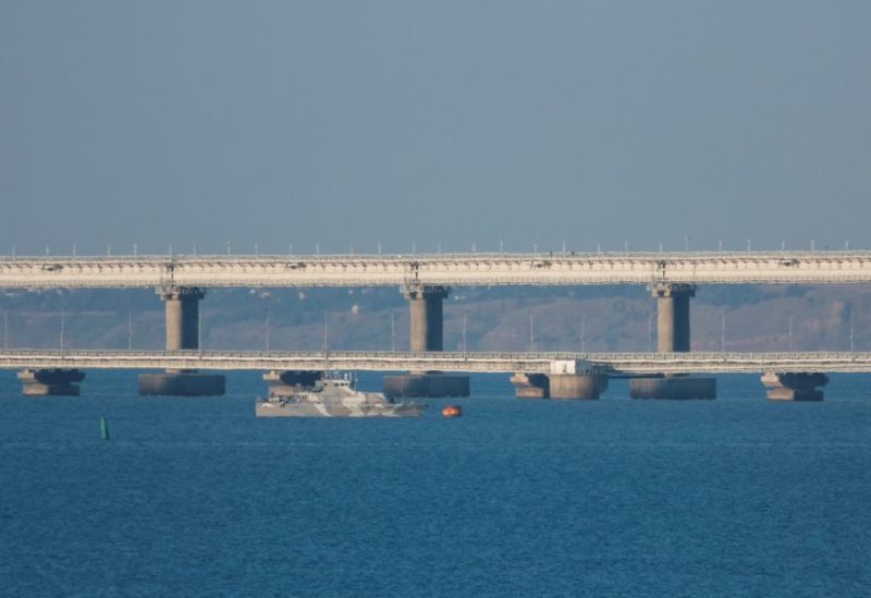 An armed ship sails next to Crimean bridge connecting the Russian mainland with the peninsula across the Kerch Strait, Crimea, July 17, 2023. REUTERS/Stringer