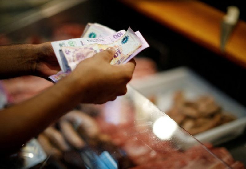 A customer pays for pork meat in a local market in Buenos Aires, Argentina March 14, 2023. REUTERS/Agustin Marcarian/File Photo