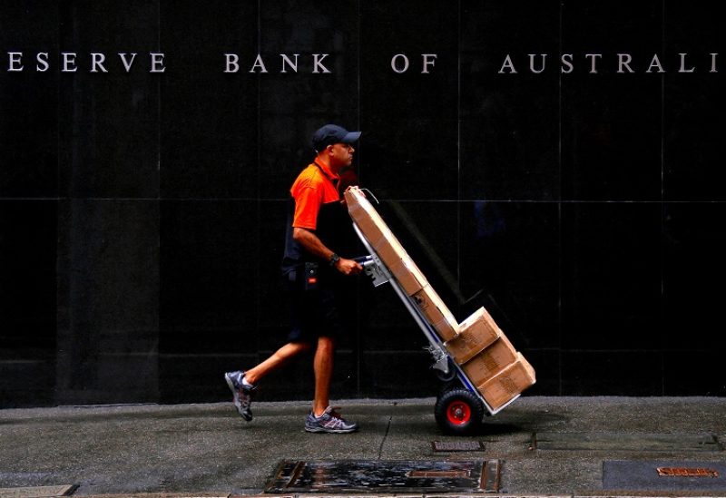 FILE PHOTO: A worker delivering parcels pushes a trolley past the Reserve Bank of Australia building in central Sydney, Australia, March 7, 2017. REUTERS/David Gray/File Photo