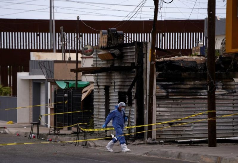 A forensic technician works at a scene where a man threw a Molotov cocktail bomb after being kicked out of a bar for bad behavior, leaving several victims, according to Sonora state authorities, in San Luis Rio Colorado, Mexico July 22, 2023. REUTERS