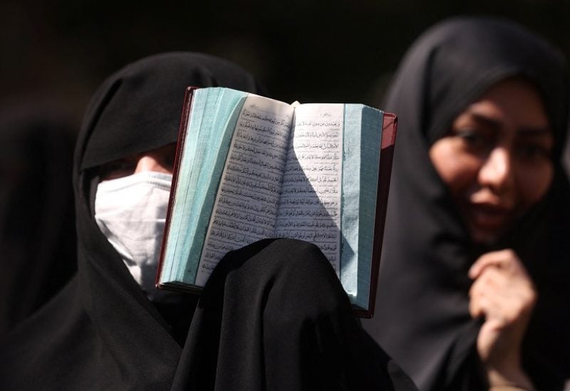 An Iranian protester holds the Quran in her hand during a protest against a man who burned a copy of the Quran outside a mosque in the Swedish capital Stockholm, in front of the Swedish Embassy in Tehran, Iran June 30, 2023. Majid Asgaripour/WANA (West Asia News Agency) via REUTERS ATTENTION EDITORS - THIS PICTURE WAS PROVIDED BY A THIRD PARTY.