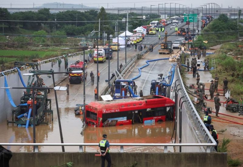 Rescue workers are seen near a recovered electric bus during a search and rescue operation near an underpass that has been submerged by a flooded river caused by torrential rain in Cheongju, South Korea, July 16, 2023. REUTERS