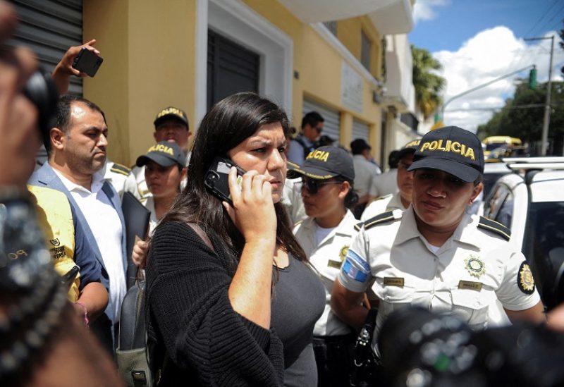 Andrea Reyes, lawyer and elected Deputy for the Semilla party, uses a cellphone as police officers stand guard during a raid on the headquarters of Guatemalan presidential candidate Bernardo Arevalo’s Semilla party, a month before the run-off election, in Guatemala City, Guatemala July 21, 2023. REUTERS/Cristina Chiquin