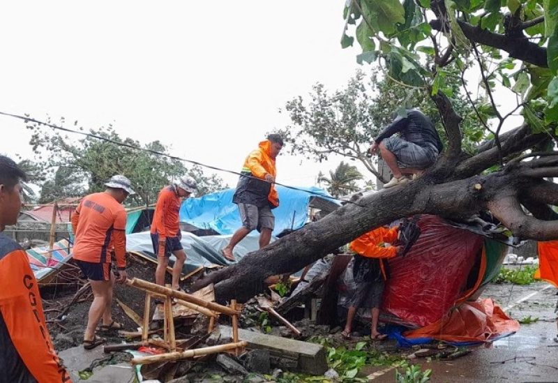Members of the Philippine Coast Guard remove a fallen tree from a road following the onslaught of Typhoon Doksuri in Buguey, Cagayan province, Philippines, July 26, 2023. Philippine Coast Guard/Handout via REUTERS THIS IMAGE HAS BEEN SUPPLIED BY A THIRD PARTY. NO RESALES. NO ARCHIVES