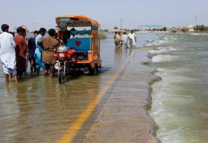Displaced people stand on flooded highway, following rains and floods during the monsoon season in Sehwan, Pakistan, September 16, 2022. (Reuters)
