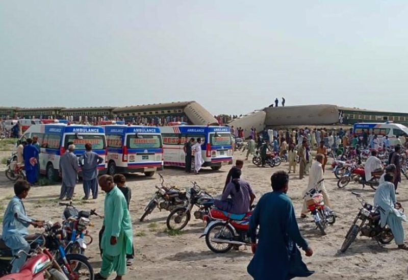 Local residents and ambulances are seen beside carriages following the derailment of a passenger train in Nawabshah, in Pakistan's southern Sindh province on August 6, 2023. © AFP