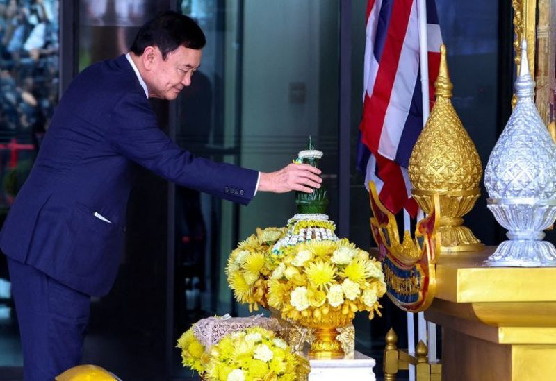 Former Thai Prime Minister Thaksin Shinawatra, who is expected to be arrested upon his return as he ends almost two decades of self-imposed exile, pays his respects to a portrait of Thailand's King Maha Vajiralongkorn and Queen Suthida at Don Mueang airport in Bangkok, Thailand August 22, 2023. REUTERS/Athit Perawongmetha