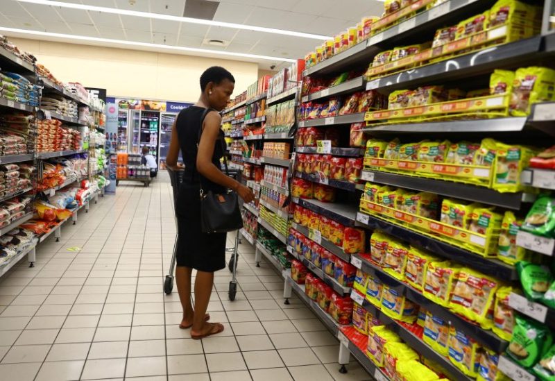 A customer compares prices while shopping at a Pick and Pay shop in East London, in the Eastern Cape province, South Africa, March 17, 2023. REUTERS/Siphiwe Sibeko