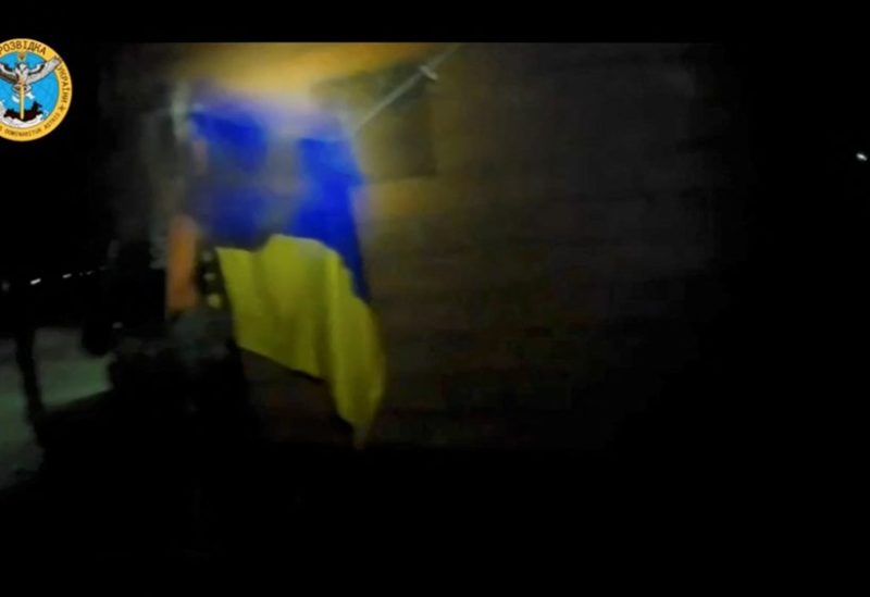 A Ukrainian soldier hangs a Ukrainian flag during a 'special operation' by Ukrainian forces at a location given as near Olenivka and Mayak settlements, Crimea, in this screengrab obtained from a handout video released on August 24, 2023. Ukrainian Main Directorate of Intelligence/Handout via REUTERS /file photo