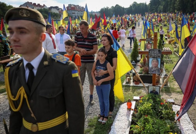People react as they visit the tombs of their relatives, Ukrainian servicemen who were killed in a fight against Russian troops, amid Russia's attack on Ukraine, during the Independence Day in Lviv, Ukraine August 24, 2023. REUTERS/Roman Baluk