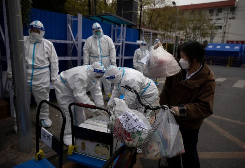 A woman delivers food to a residential compound that is under lockdown as outbreaks of coronavirus disease (COVID-19) continue in Beijing, China November 28, 2022. REUTERS/Thomas Peter/File Photo