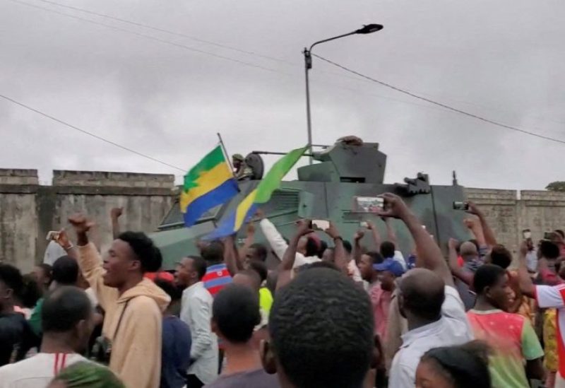 A military vehicle passes by people celebrating after military officers announced they had taken power, after the state election body announced President Ali Bongo had won a third term, in Port Gentil, Gabon August 30, 2023 in this still image obtained from social media video. Gaetan M-Antchouwet
