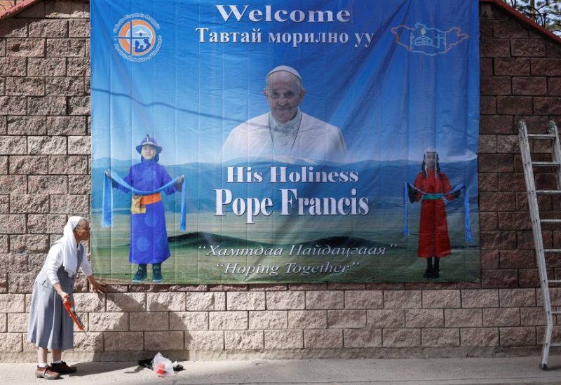 A nun installs a poster with an image of Pope Francis outside the bishop’s house, where he is expected to stay during his Apostolic Journey, one day ahead of his arrival in Ulaanbaatar, Mongolia August 31, 2023. REUTERS/Carlos Garcia Rawlins