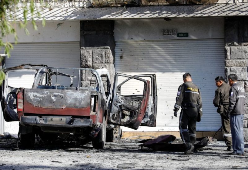 Police officers check the remains of a car, that according to authorities was loaded with two gas tanks and later exploded when suspects set it on fire, seemingly targeting Ecuador's prison agency SNAI, in Quito, Ecuador August 31, 2023. REUTERS/Karen Toro