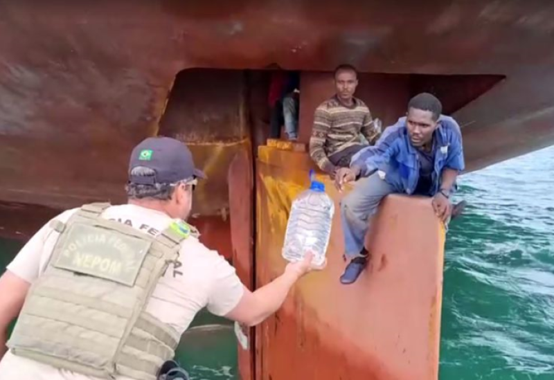 Nigerian migrants are rescued by Brazilian police as they sit on the rudder of a ship after crossing the crossing the Atlantic in this undated frame grab from video