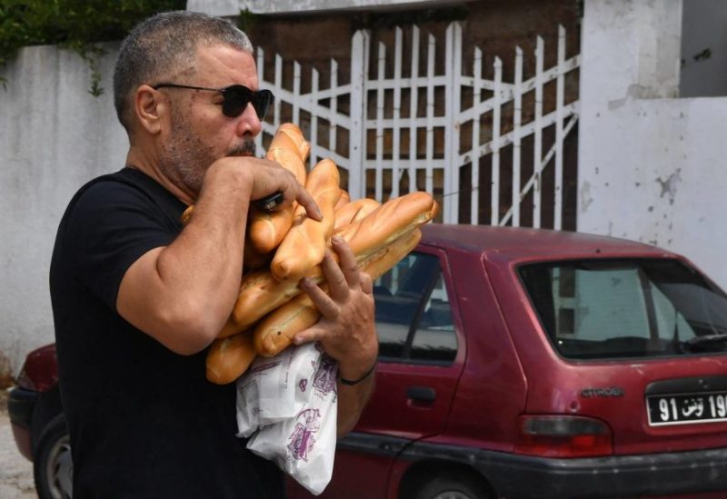 A Tunisian citizen was able to buy quantities of bread after waiting his turn in the long queues. (AFP)