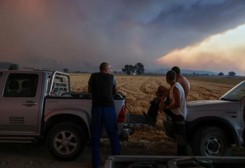 Locals watch a wildfire burning near the village of Avantas in the region of Evros, Greece, August 21, 2023. REUTERS