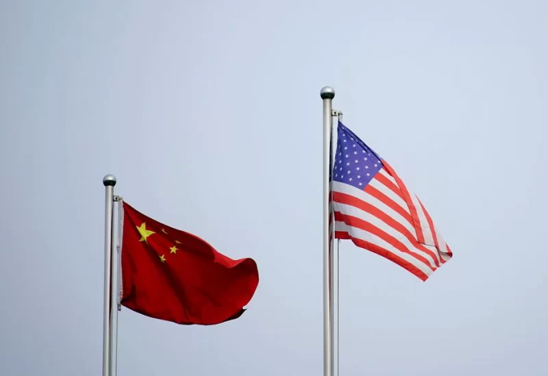 Chinese and U.S. flags flutter outside a company building in Shanghai, China April 14, 2021. REUTERS