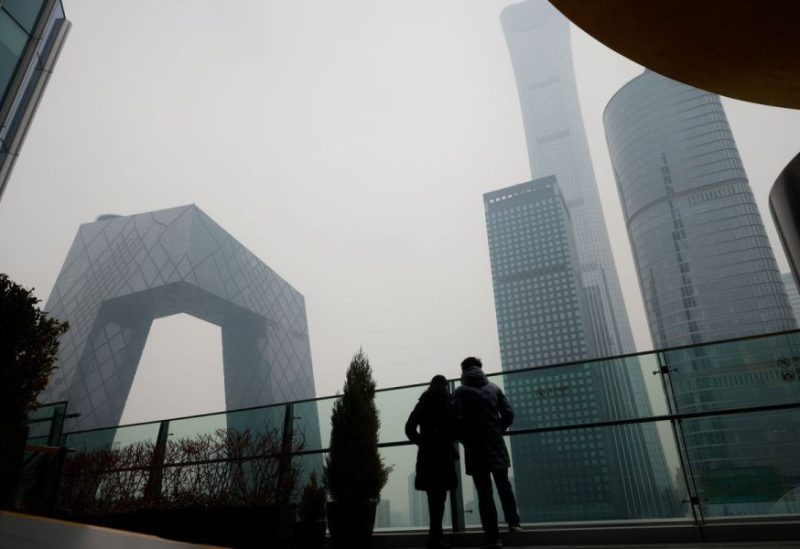 People look at the skyline of the central business district (CBD), on the day of the opening session of the National People's Congress (NPC), during a hazy day in Beijing, China, March 5, 2021. REUTERS