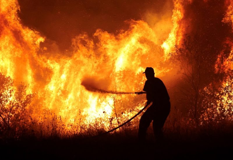FILE PHOTO: A firefighter tries to extinguish a wildfire burning at the industrial zone of the city of Volos, in central Greece, July 26, 2023. REUTERS/Alexandros Avramidis/File Photo