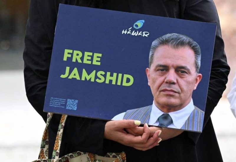 A demonstrator holds a picture of Iranian-German Jamshid Sharmahd, who has been sentenced to death in Iran, and with the lettering “Free Jamshid” during a demonstration for his release in front of the German Foreign Ministry in Berlin on July 31, 2023. (AFP)