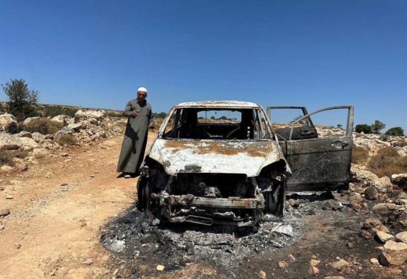 Palestinian Saber Asaliyyeh reacts near a burned car after a confrontation with a group of Israeli settlers in Burqa near Ramallah in the Israeli-occupied West Bank, August 9, 2023. (Reuters)