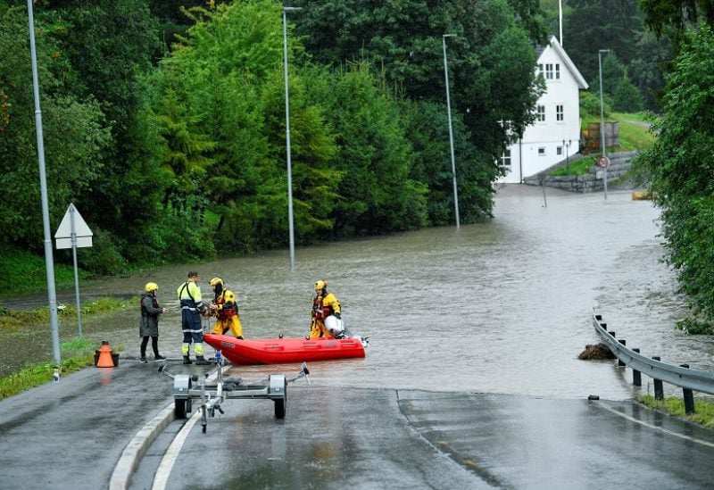 Nurse Ingrid-Marie Nyborg gets help from rescue teams, during the weather system "Hans", to get to work in Oslo, Norway August 8, 2023. The house she lives in is not in direct danger from the bodies of water, but there was no other way out than with the fire service's rubber boat. NTB/Rodrigo Freitas via REUTERS ATTENTION EDITORS - THIS IMAGE WAS PROVIDED BY A THIRD PARTY. NORWAY OUT. NO COMMERCIAL OR EDITORIAL SALES IN NORWAY.