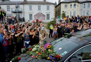A hearse carrying the coffin of late Irish singer Sinead O'Connor passes outside her former home during her funeral procession as fans line the street to say their last goodbye to her, in Bray, Ireland, August 8, 2023. REUTERS/Clodagh Kilcoyne