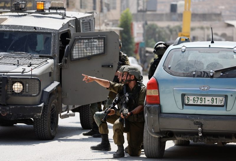 Israeli troops guard, at the scene of a shooting, near Hebron, in the Israeli-occupied West Bank August 21, 2023. REUTERS/Mussa Qawasma