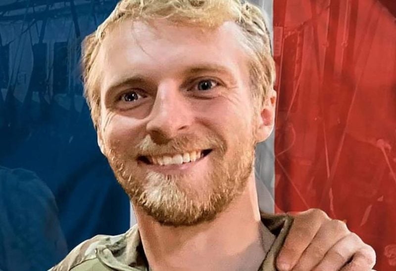 This undated and unlocated handout photograph taken and released by the French Army General Staff on their Facebook account shows French special force member sergeant Nicolas Mazier, a member of the 10th air parachute commando killed in service during an anti-terrorism operation on August 28, 2023, posing with a French flag in the background. (Handout / Etat Major des Armees / AFP) /
